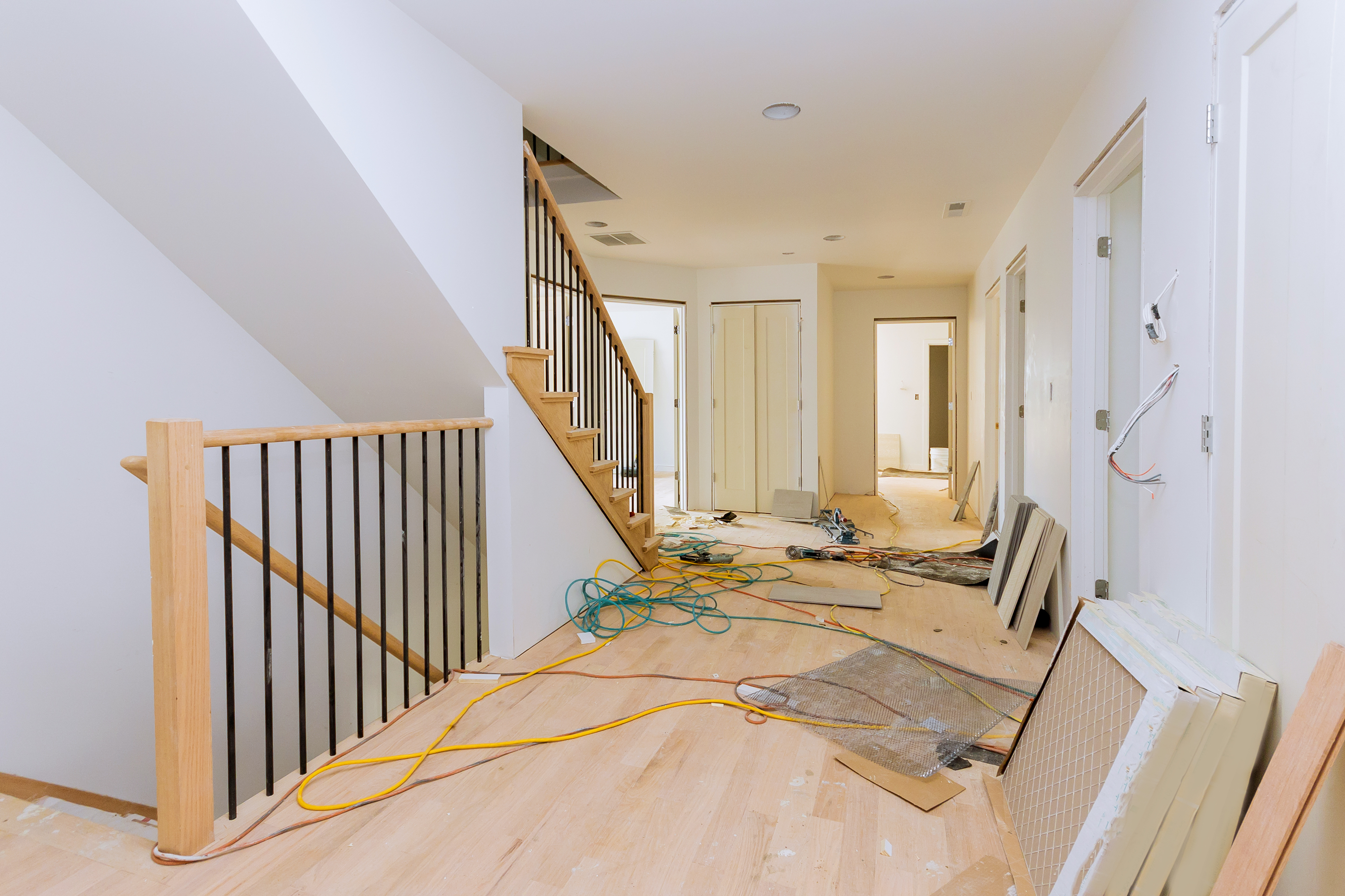 Modern home interior under construction with wooden stairs and metal railings