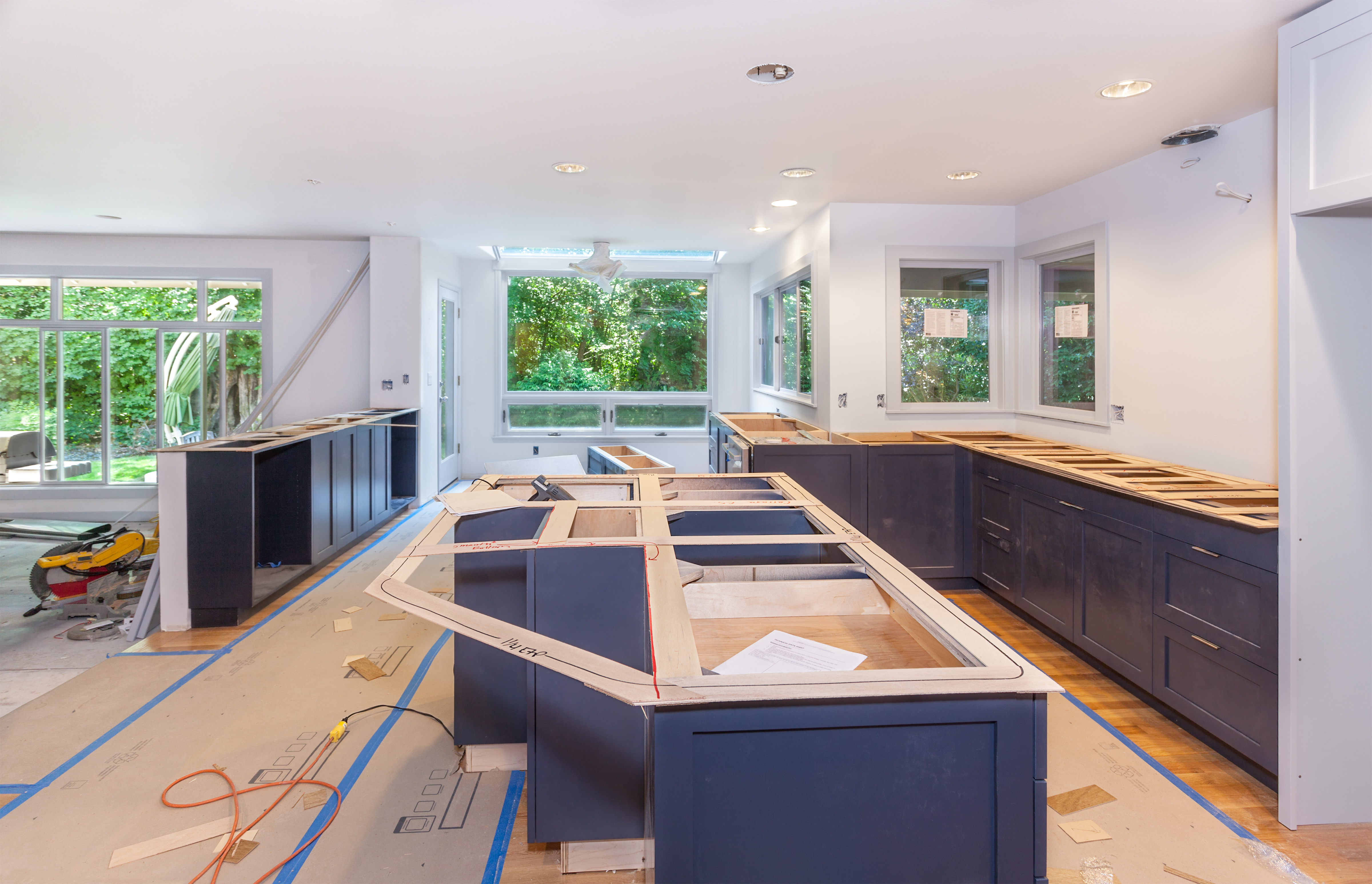 Kitchen renovation in progress with dark cabinetry and wooden countertops under construction